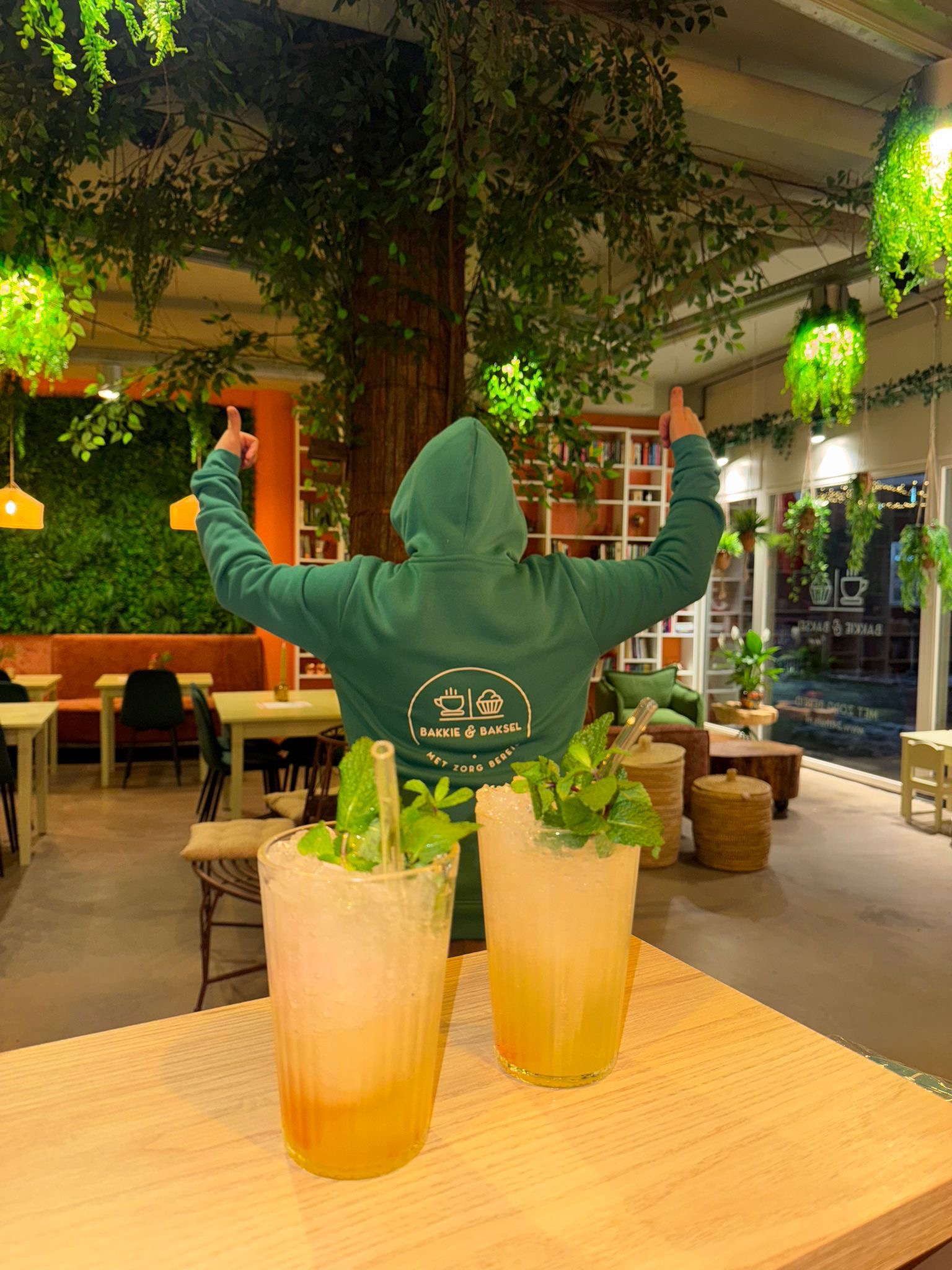 Jongere in Bakkie & Baksel-hoodie met limonade in het interieur van de koffiebar